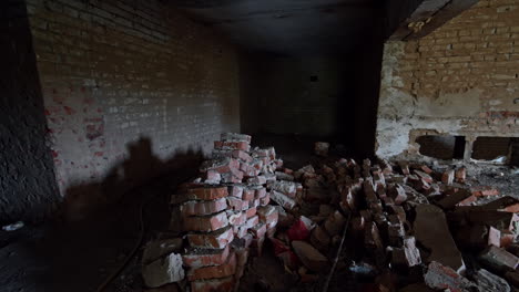 piles of broken old bricks are inside the dark premise. building renovation or reconstruction.
