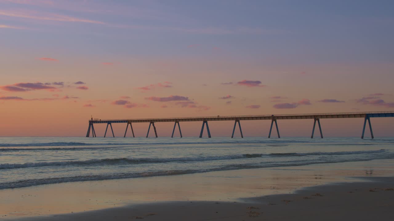 muelle de la playa de la saile durante una puesta de sol romántica con colores pastel en francia