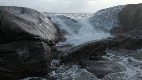 waves hitting rocks. evening shot. dark ocean, white waves. slow motion.