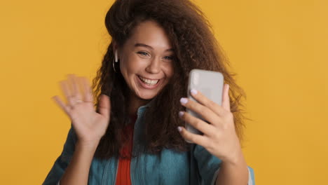 caucasian curly haired woman video calling on smartphone.