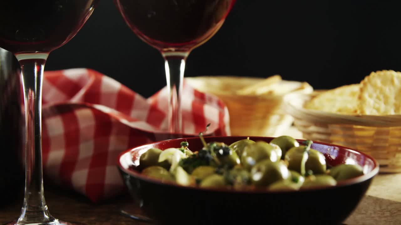tapas de vino rojo y aceitunas verdes en la mesa