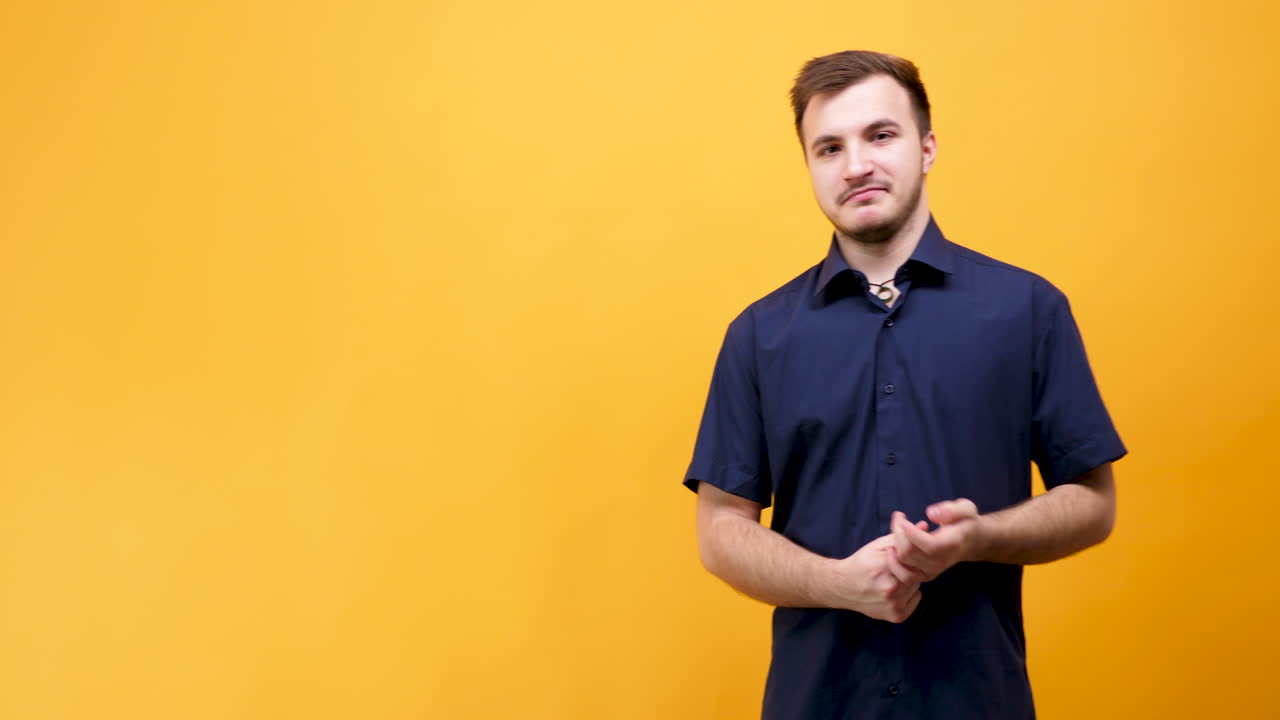 Uomo con camicia blu su sfondo giallo