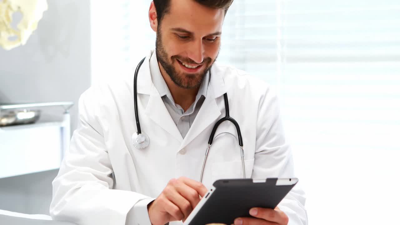 Medico maschio che per mezzo della compressa digitale