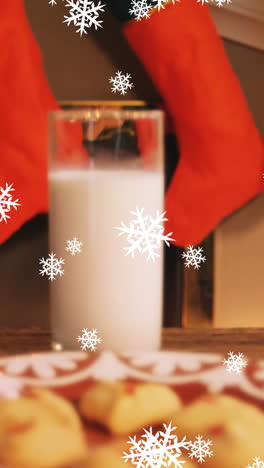 animación de nieve cayendo sobre leche y galletas en navidad