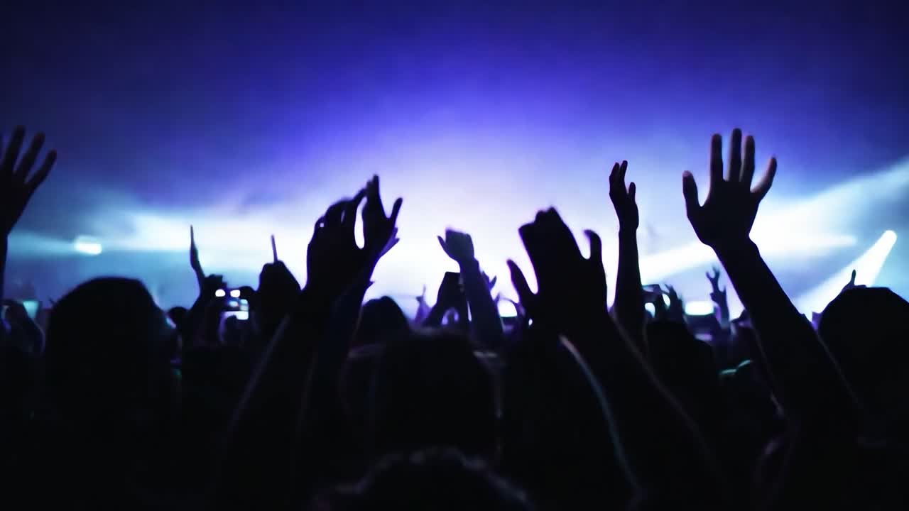 los miembros de la audiencia aplauden y levantan las manos en emoción durante un animado concierto lleno de música y energía