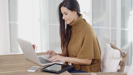 Mujer-Atractiva-Sentada-Escribiendo-En-Una-Computadora-Portátil