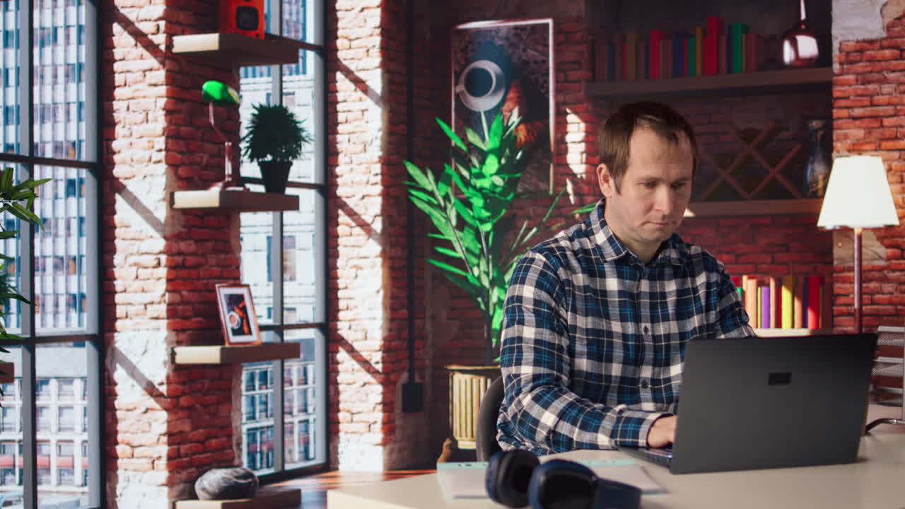 직원이 노트북에서 스프레드시트를 작성하고 음악을 듣고 있습니다.