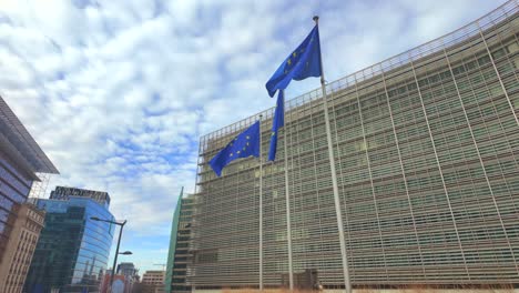 wide view of eu flags fluttering among brussels city architecture