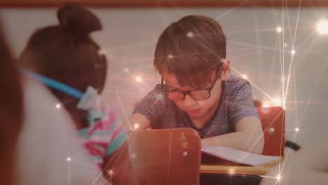 una red brillante de conexiones contra un niño caucásico que estudia sentado en su escritorio en clase en la escuela