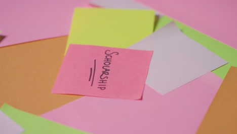 education concept of revolving sticky notes with scholarship written on top note 1