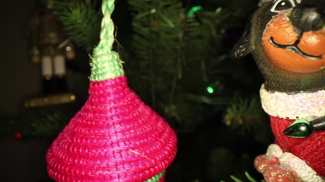 손으로 만든 초록색과 은색의 크리스마스 장식품에서 벗어나서 멀리서 견과류 개기를 보여줍니다.