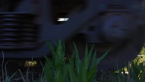closeup of a train's wheels over a railway on a rural area.