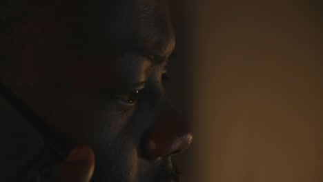 Close-Up-Of-Black-Male-Picking-Up-Phone-In-Dark-Home-Office