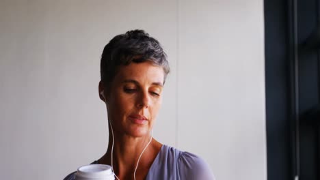 Businesswoman-having-coffee-while-listening-music-on-mobile-phone-4k