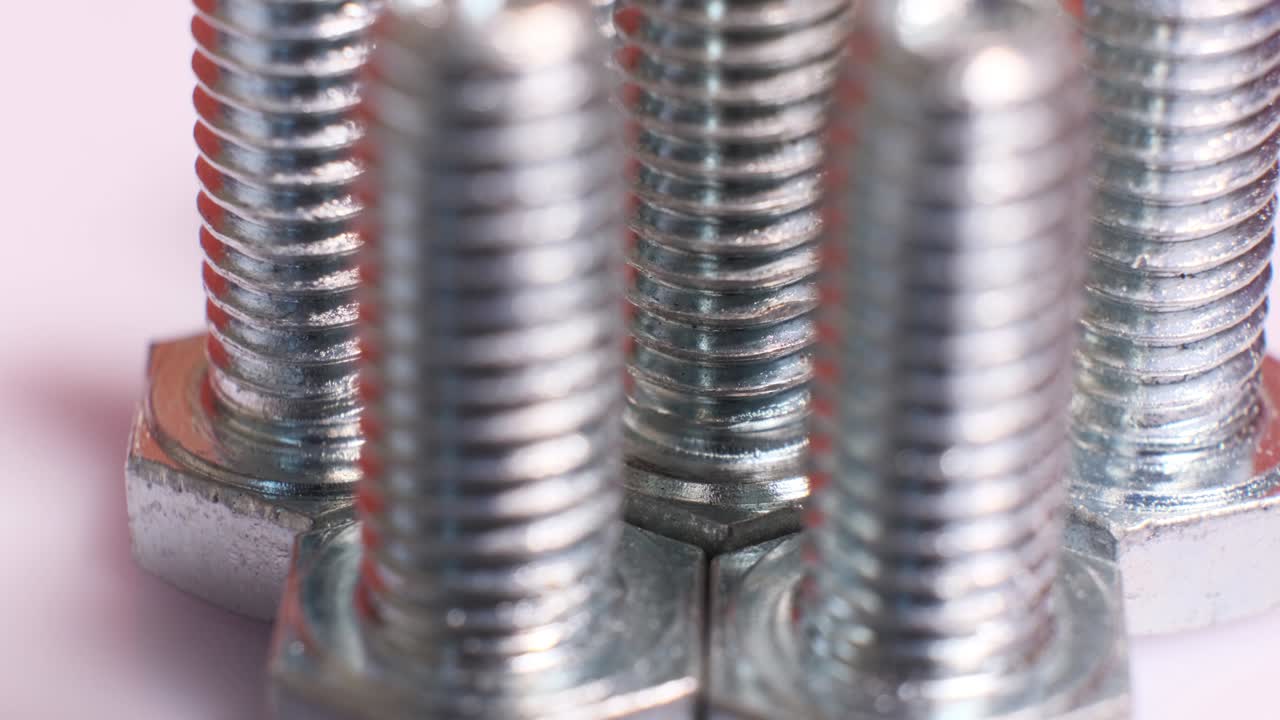 grupo giratorio de tornillos metálicos galvanizados de primer plano. pernos de acero inoxidable aislados sobre un fondo blanco.