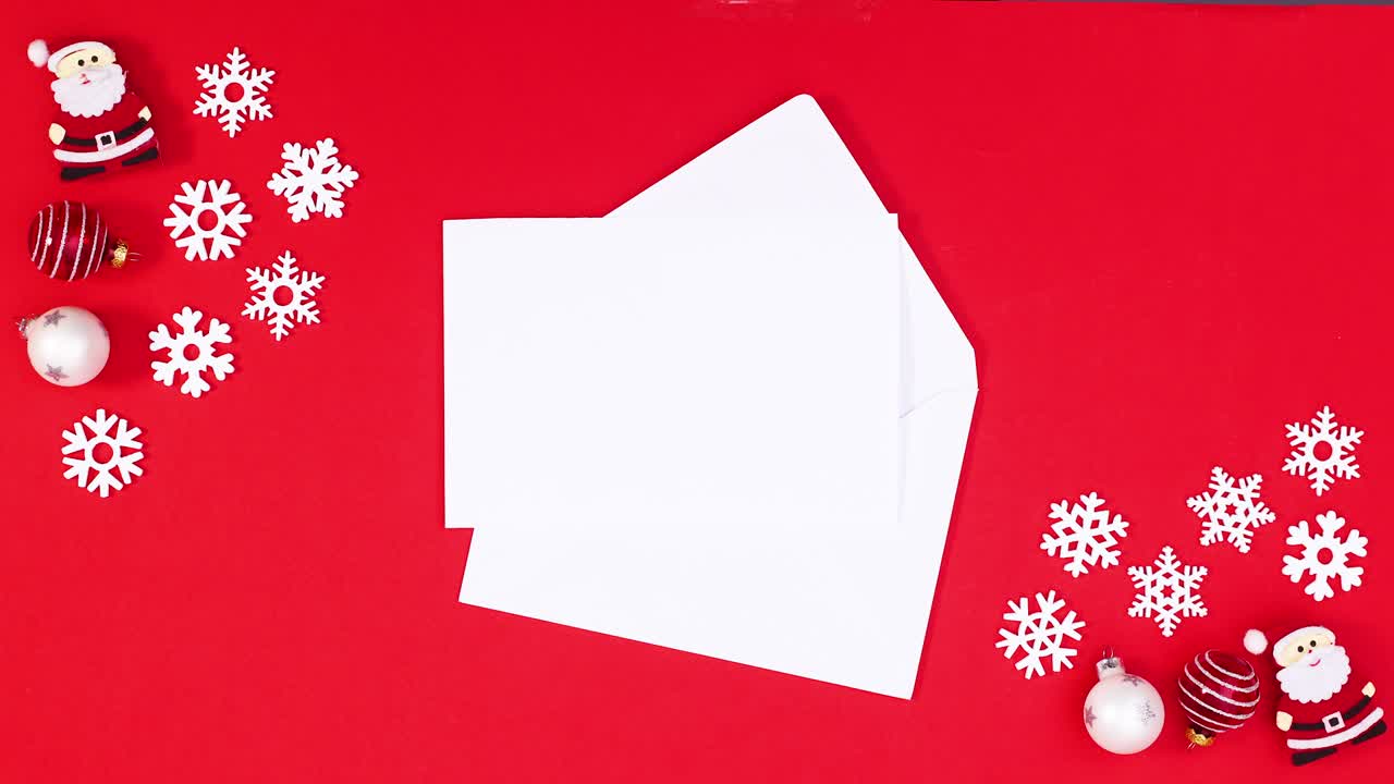 papel para texto en sobre rodeado de copos de nieve y adornos navideños en tema rojo. stop motion