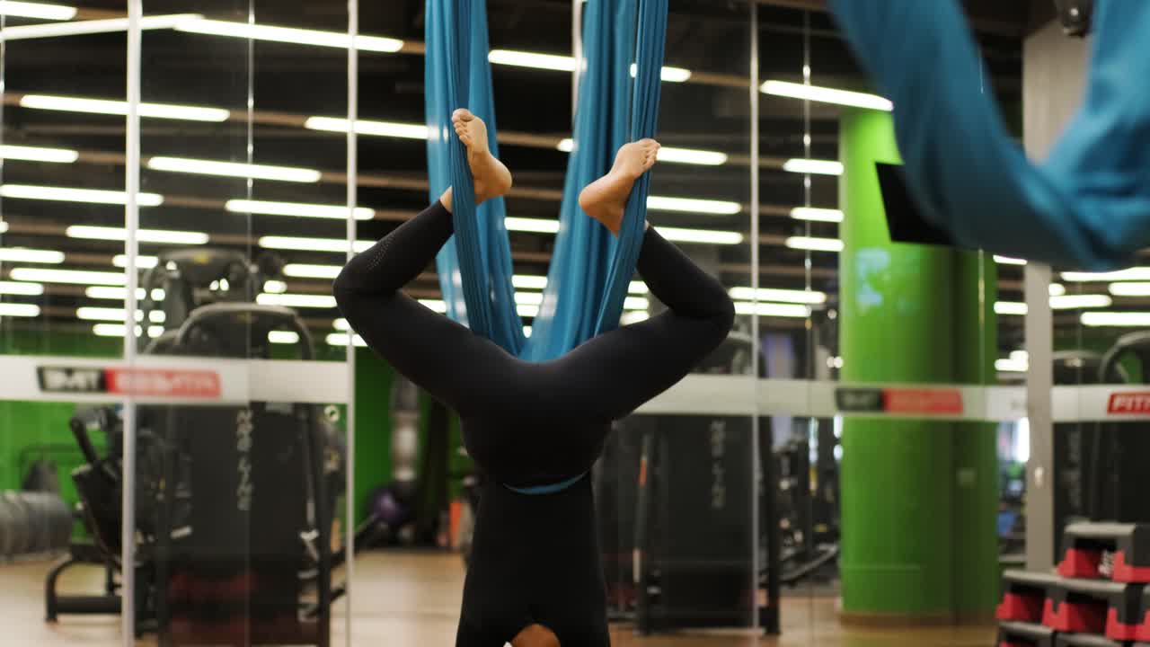 여자가 피트니스 스튜디오에서 에어로 요가 스트레칭 운동을 하고 있습니다. 여성의 건강한 생활 방식. 운동 체육관