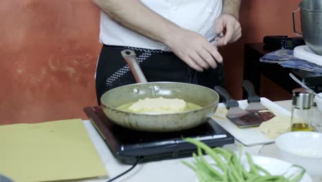 chef-fried-breaded-meat-cotoletta-italian-dish-cousin-in-olive-oil-close-up-of-skilled-hands