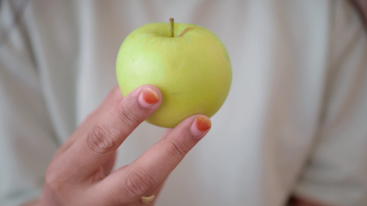 зеленое яблоко в руке