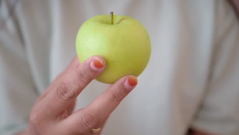 a green apple in a hand