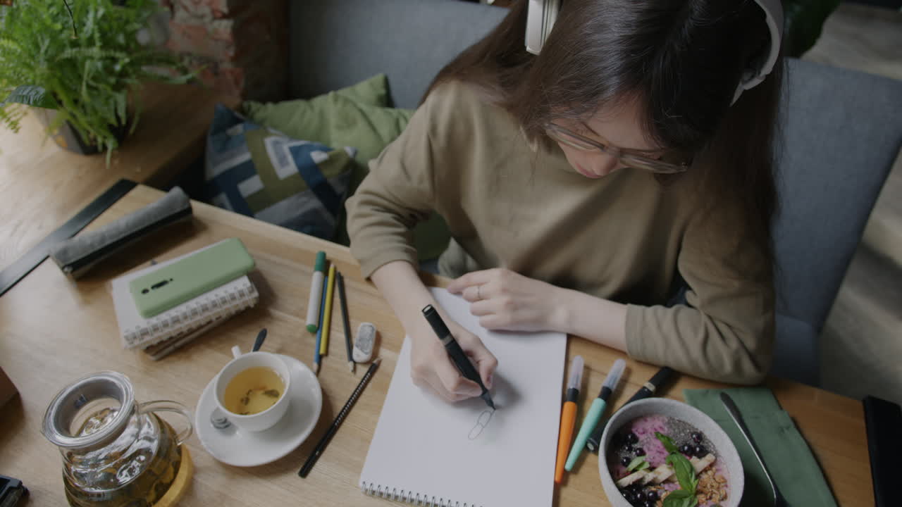 Young Woman Drawing in a Cafe