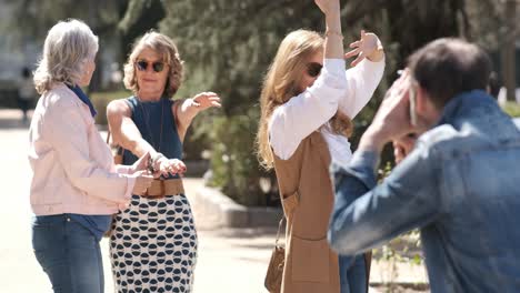 man shooting mature women dancing in park