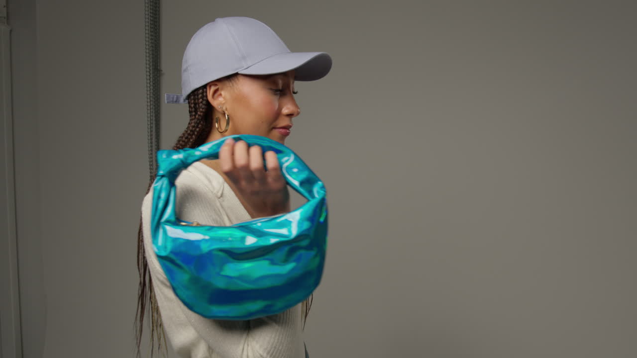 женщина-влиятельница социальных сетей, производящая пользовательский контент в студии, держащая различные модные сумочки 1