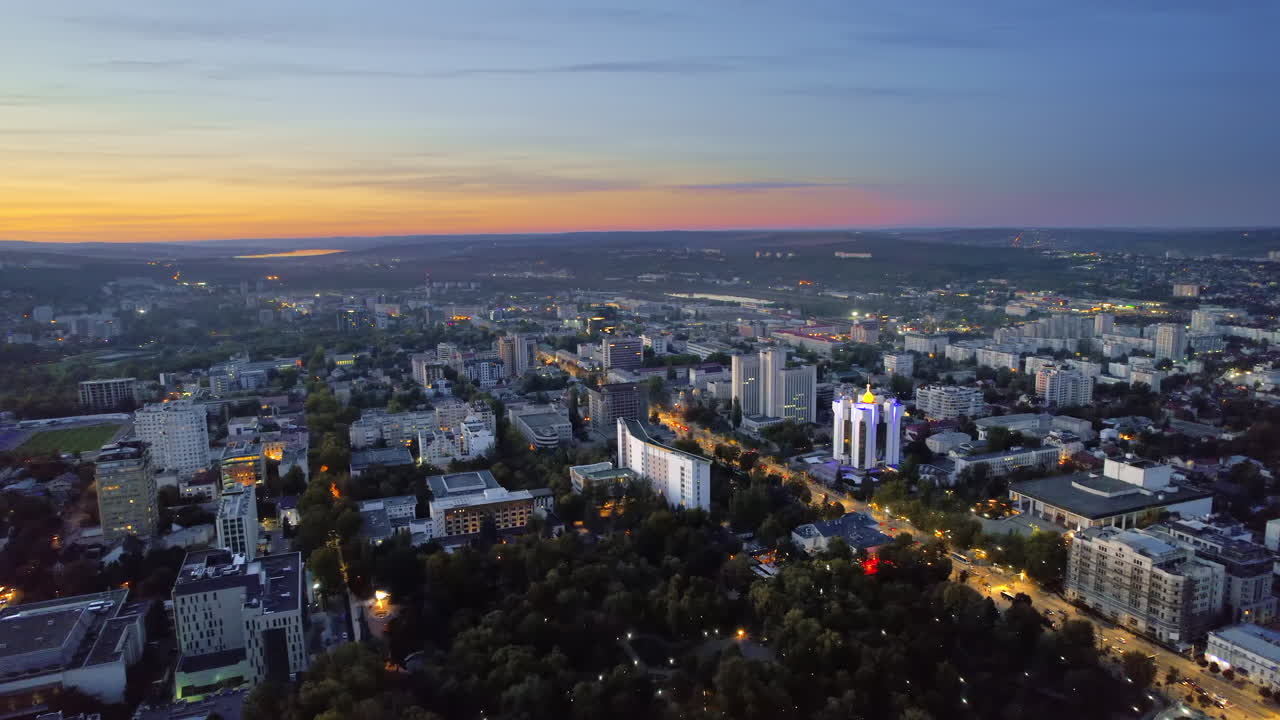 Aerial drone view of Chisinau at evening, Moldova. View of city centre with presidency, parliament and park, multiple buildings, roads, illumination