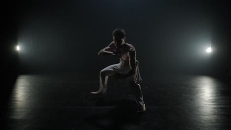 luchadores de capoeira realizando movimientos dinámicos en el escenario. artes marciales, danza y acrobacias en acción. atletas de pecho desnudo mostrando fuerza, flexibilidad y técnica bajo los reflectores