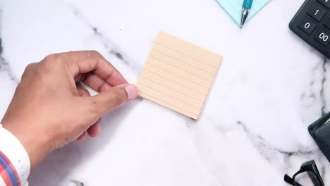persona que escribe en una nota adhesiva
