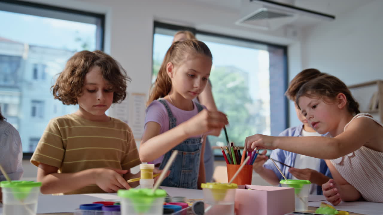 Pupils studying art class taking colorful pencils closeup. Group school children