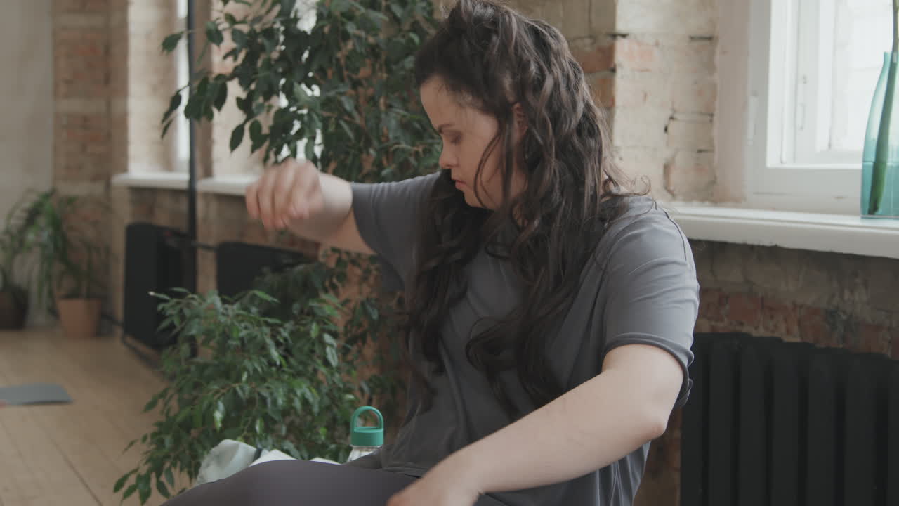 Young Woman With Down Syndrome Getting Ready For Yoga Class