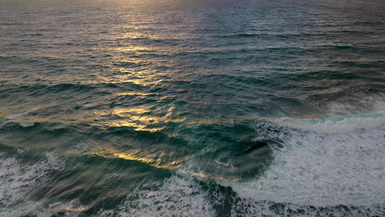 puesta de sol revelada por un dron mientras las olas chocan cerca de la costa de una hermosa playa en méxico