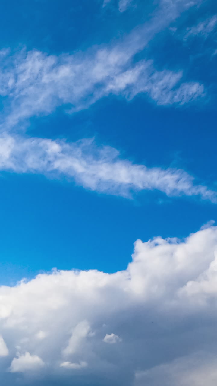 Amazing azure sky with cirro-cumulus white clouds. Light clouds change into heavy grey once. Low angle view. Timelapse. Vertical video