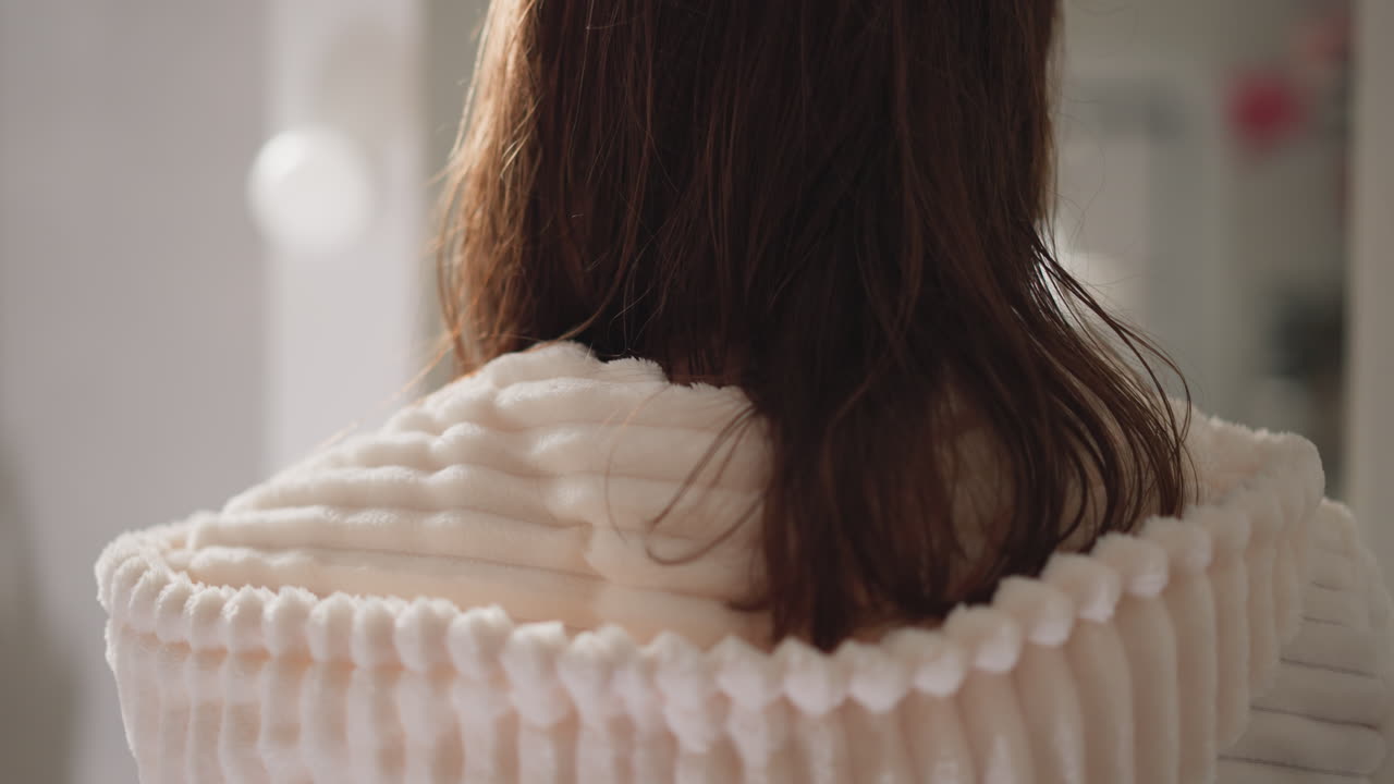 샤워를 마친 후 화장실에서 거울 에 서있는 여성. 은 여자는 저녁 치료 후 편안한 따뜻한 욕조에서 느린 동작으로 휴식을 취합니다.