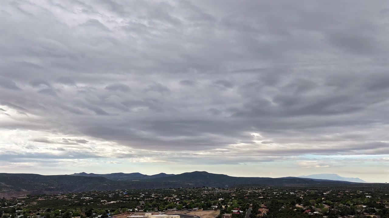 A dramatic drone timelapse captures surreal UFO-like lenticular clouds in a southwestern sky. The ethereal atmospheric formation creates an epic weather background.