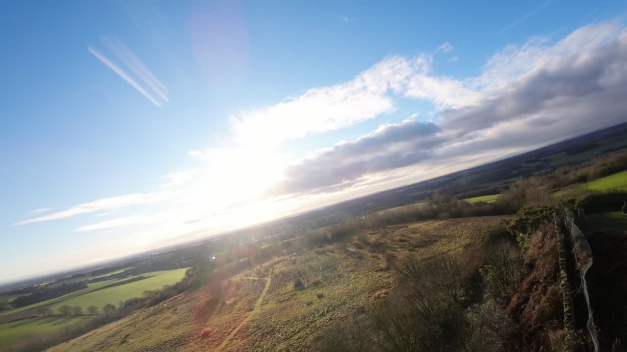Drone FPV che vola attraverso il confine dei terreni agricoli di Billinge Hill Beacon nel paesaggio autunnale del Lancashire.