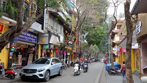 motorbikes and cars navigate a bustling street