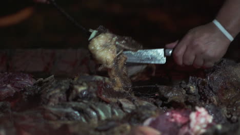 manos girando costillas de carne sobre la parrilla en un asado argentino - cámara lenta