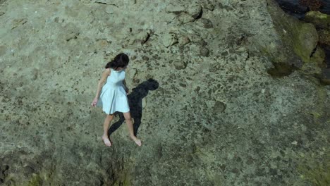 Aerial-slow-motion-shot-of-pretty-girl-in-white-dress-walk-on-the-beach-2