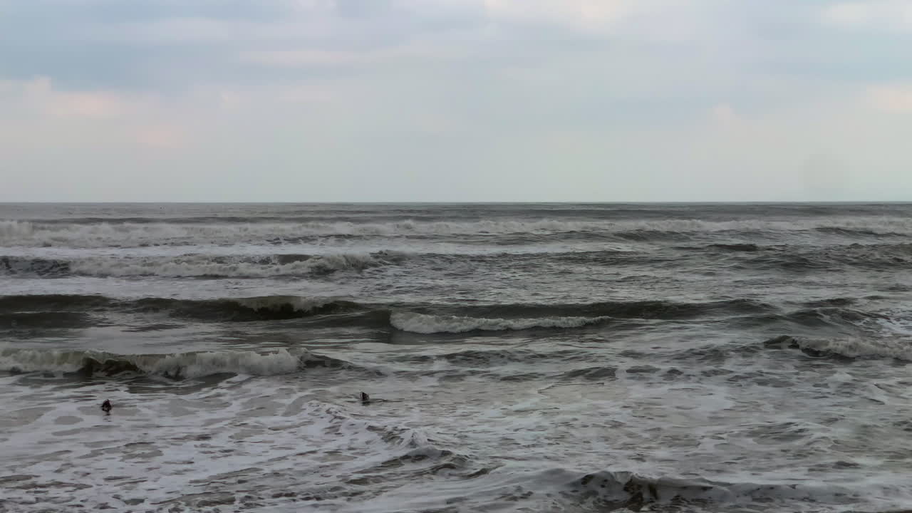Choppy dramatic ocean waves rolling under an overcast sky, moody seascape.