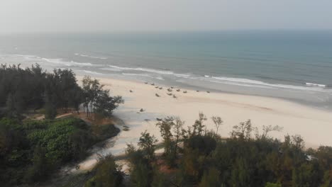 Wide-view-of-local-beach-at-Vietnam-with-local-fishing-boats,-aerial