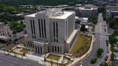 aerial shot of american flag waving infront of unrecognizable usa government building