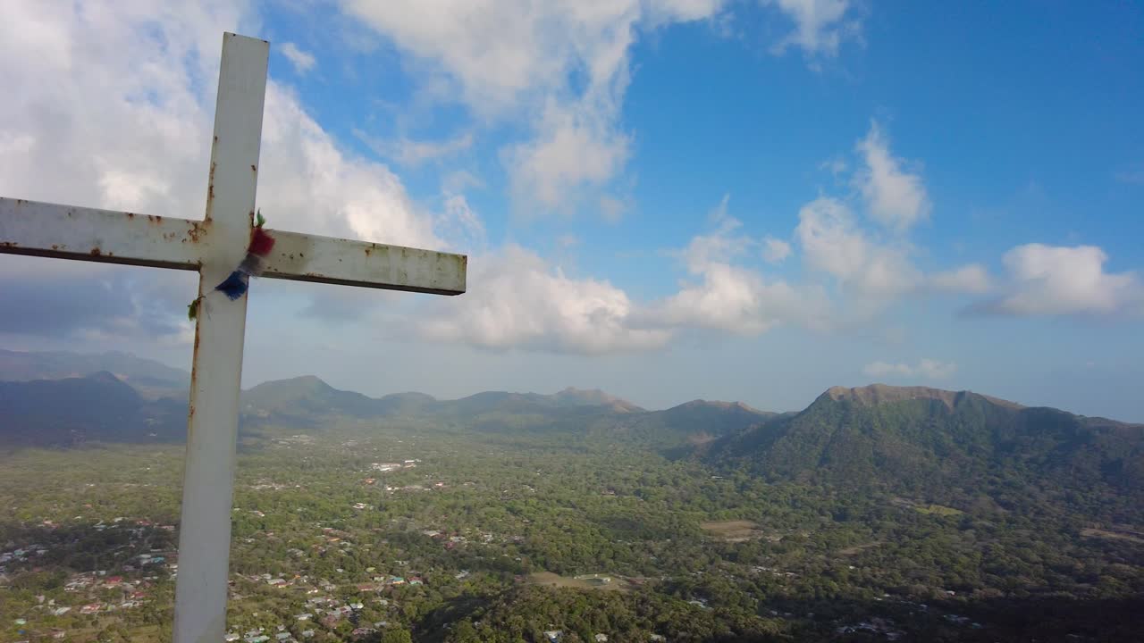 A towering crucifix perched atop a majestic mountain, surrounded by pristine natural beauty