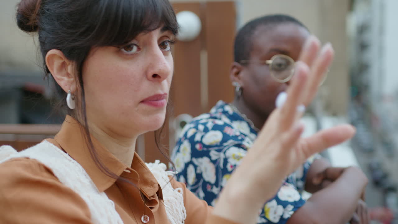 젊은 여성 동료들이 도시 지붕에서 휴식을 취하고 이야기하고 있습니다.