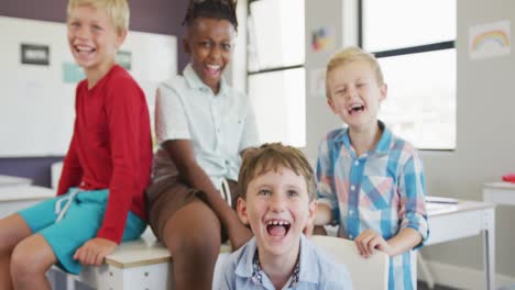 video de niños diversos sentados en los escritorios de la escuela y riendo