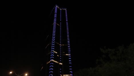 beautiful skyscraper with blue lights at night in paris. low angle.