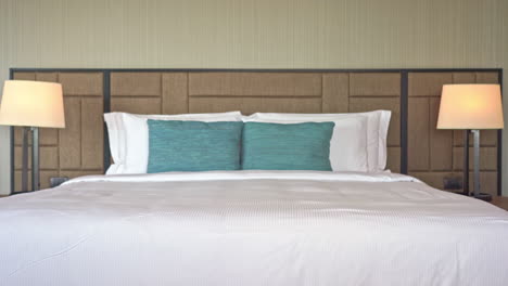 tilt-up from the foot of a hotel resort bed to the wood patterned headboard