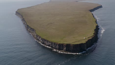 fontur lighthouse at the end of langanes peninsula surrounded by calm sea in iceland