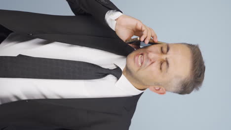 Vertical-video-of-Angry-talking-businessman-on-the-phone.
